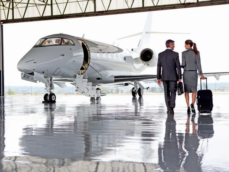 Business couple walking towards private jet